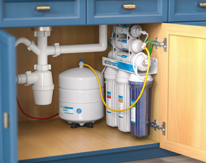 What Is a Reverse Osmosis System Under-sink water filtration system featuring multiple filter cartridges, a pressurized storage tank, and integrated plumbing beneath a blue kitchen cabinet.